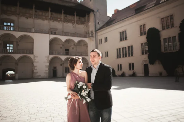 Beautiful couple, man, girl with long pink dress posing in old castle near columns. Krakow Vavel — Stock Photo, Image