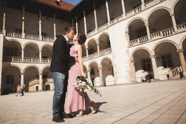 Beautiful couple, man, girl with long pink dress posing in old castle near columns. Krakow Vavel — Stock Photo, Image