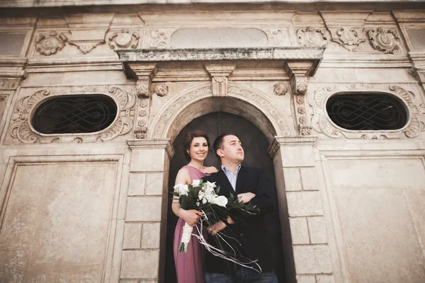 Πανέμορφο γαμήλιο ζεύγος, τον γαμπρό και νύφη με ροζ φόρεμα περπάτημα στην παλιά πόλη της Κρακοβίας — Φωτογραφία Αρχείου