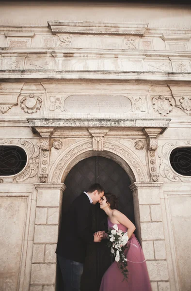 Hermosa pareja de boda, novio y novia con vestido rosa caminando en la ciudad vieja de Cracovia —  Fotos de Stock