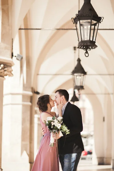 Casal de casamento romântico, homem e mulher, posando perto de coluna de edifício velho — Fotografia de Stock