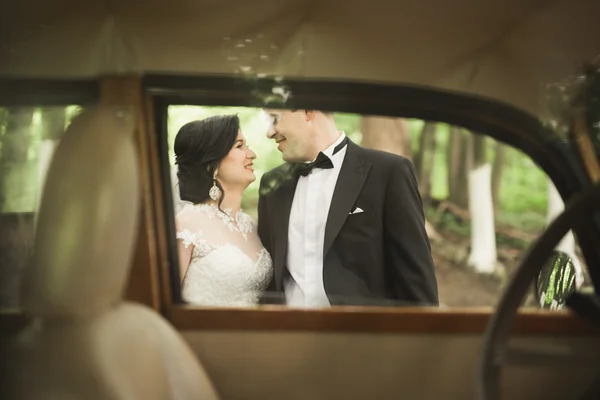 スタイリッシュな結婚式、花嫁、新郎のキスと秋にレトロな車の近くハグ — ストック写真