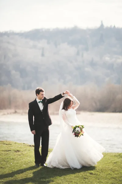 아름 다운 결혼식 커플, 신부, 신랑 포즈 및 높은 산의 배경 필드에 산책 — 스톡 사진