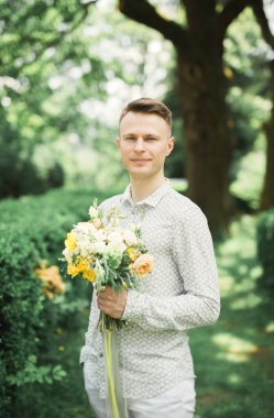 Adam, mükemmel bir düğün buket ile poz damat