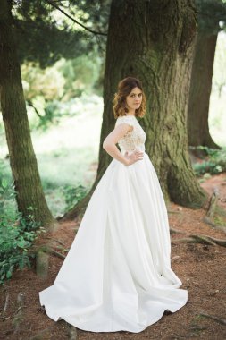 Gelin. Güzel sarışın kadın çiçek çelenk ve buket sıcak yaz gününde park