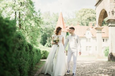 Yeni evli çift el ele tutuşurken parkta koşup zıplıyorlar.