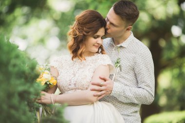 Güzel romantik bir çift yeni evliler gün batımında parkta sarılıyorlar.