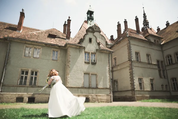 新婚快乐夫妇拥抱和微笑彼此在背景老城堡 — 图库照片