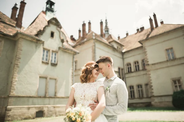 Novomanželům pózy a líbání s staré pevnosti na pozadí — Stock fotografie