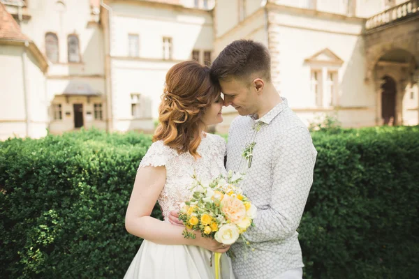 Bella coppia di sposi romantici che si abbracciano vicino al vecchio castello — Foto Stock