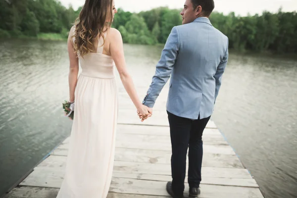 Hochzeitspaar, Braut, Bräutigam spazieren und posieren auf Seebrücke — Stockfoto