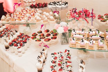 Çeşitli lezzetli tatlılar, yemek fikirleri ve kutlamalarla dolu bir büfe.