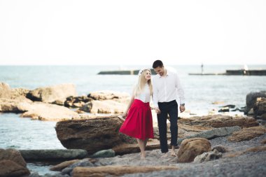 Deniz, mavi gökyüzü yakınındaki taş poz romantik sevgi dolu Çift