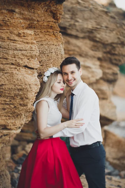 Casal amoroso romântico andando na praia com pedras e pedras — Fotografia de Stock