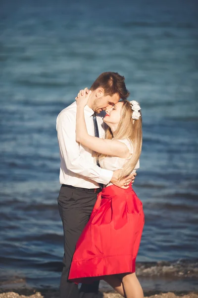 Unga lyckliga par promenader på stranden leende anläggningen runt varandra. Kärlekshistoria — Stockfoto