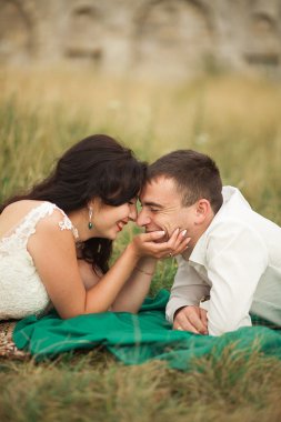 Mutlu evlilik çift yaz saati, yeşil çim üzerinde yalan