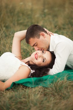 Mutlu evlilik çift yaz saati, yeşil çim üzerinde yalan