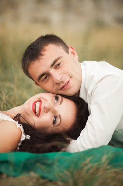 Mutlu evlilik çift yaz saati, yeşil çim üzerinde yalan