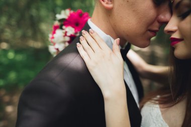 Genç ve güzel bir çift parkta öpüşüyor ve gülümsüyor.