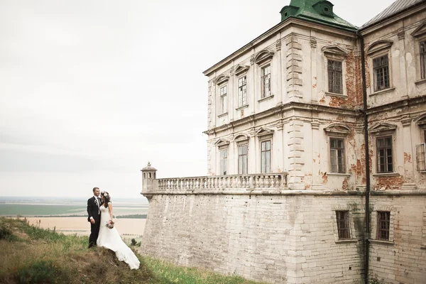 Piękny romantyczny ślub para nowożeńców przytulających się w pobliżu starego zamku — Zdjęcie stockowe