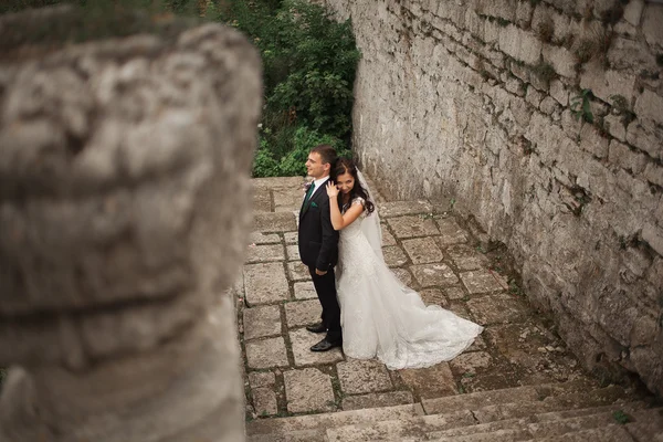 Ευτυχισμένος γάμος ζευγάρι αγκάλιασμα και το φίλημα στο παλιό κάστρο φόντο — Φωτογραφία Αρχείου