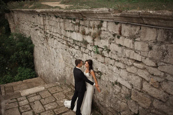 Güzel, romantik bir düğün. Yeni evliler. Eski kalenin yakınlarında sarılıyorlar. — Stok fotoğraf