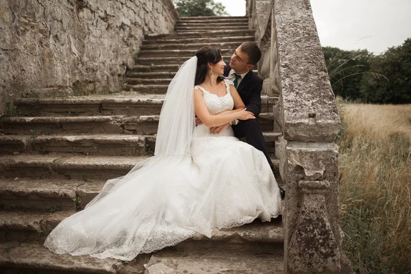 Hermosa boda romántica pareja de recién casados abrazos cerca del viejo castillo — Foto de Stock