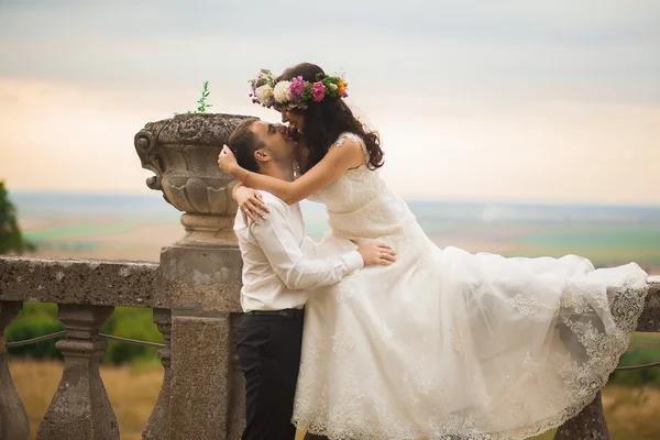 Feliz boda pareja abrazos y besos en el fondo viejo castillo — Foto de Stock