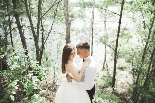 Casamento casal homem, noiva beijando e abraçando em um fundo do rio, montanhas. Retrato de beleza — Fotografia de Stock