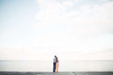 Güzel sevgi dolu çift, gurur iskelede yürüyüş uzun elbise ile