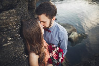 Mavi Denizi çevresinde büyük bir taş üzerinde oturan Düğün çifti