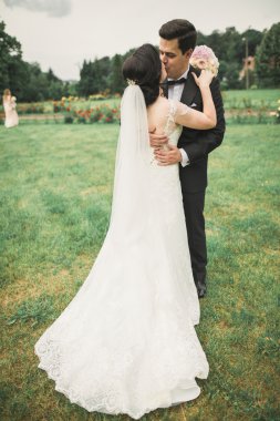 Güzel romantik bir çift yeni evliler gün batımında parkta sarılıyorlar.