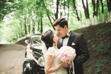 Çiçek buketi taşıyan mükemmel bir düğün çifti.