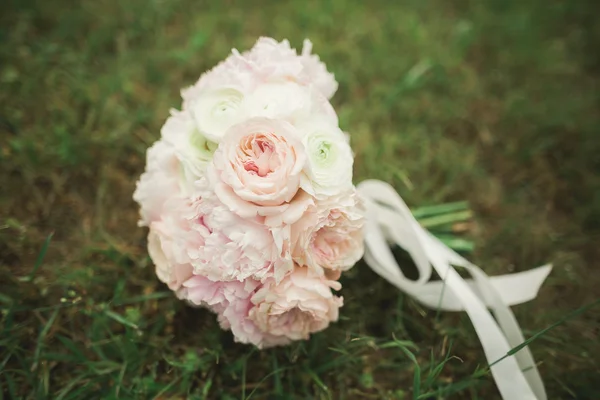 Bouquet of beautiful flowers and greenery is on the green grass — Stock Photo, Image