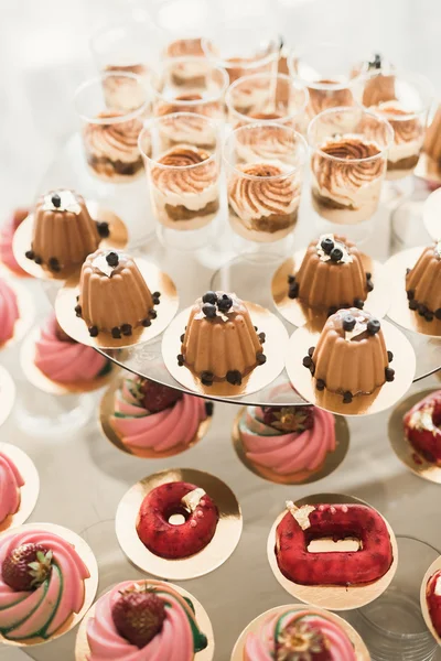 Läckra och välsmakande dessert bord med cupcakes skott i receptionen närbild — Stockfoto