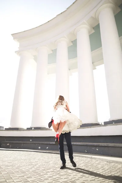 Casal bonito, noiva e noivo posando perto de grande coluna branca — Fotografia de Stock