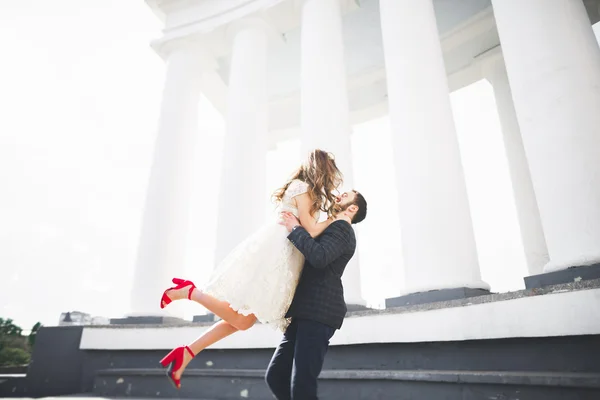 Prachtige paar, bruid en bruidegom poseren in de buurt van grote witte kolom — Stockfoto