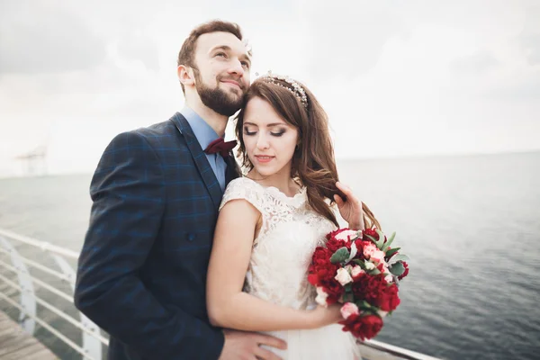 Frisch verheiratetes Hochzeitspaar am Strand bei Sonnenuntergang. — Stockfoto