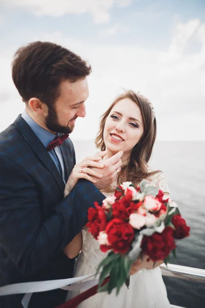 Just married wedding couple walking on the beach at sunset. — Stock Photo, Image