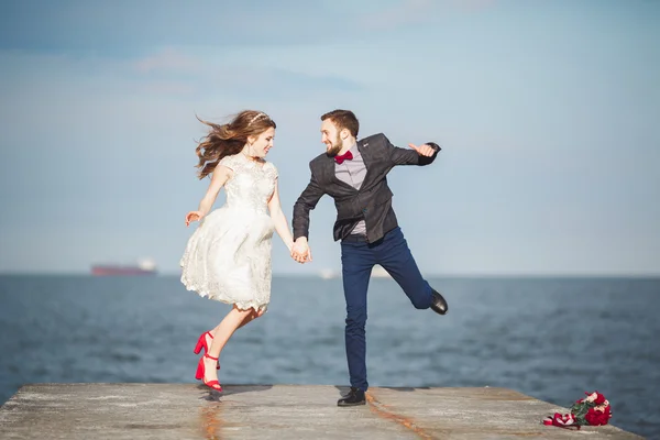 Feliz recém-casado jovem casal de casamento celebrando e se divertir no belo pôr do sol da praia — Fotografia de Stock