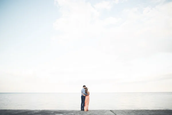 Belo casal amoroso, orgulho com vestido longo andando no cais — Fotografia de Stock