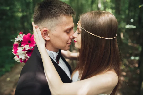 Genç ve güzel bir çift parkta öpüşüyor ve gülümsüyor.