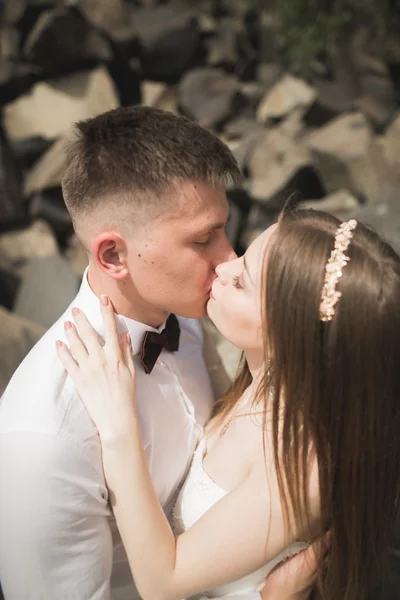 Hermosa pareja de boda en las montañas con rocas — Foto de Stock