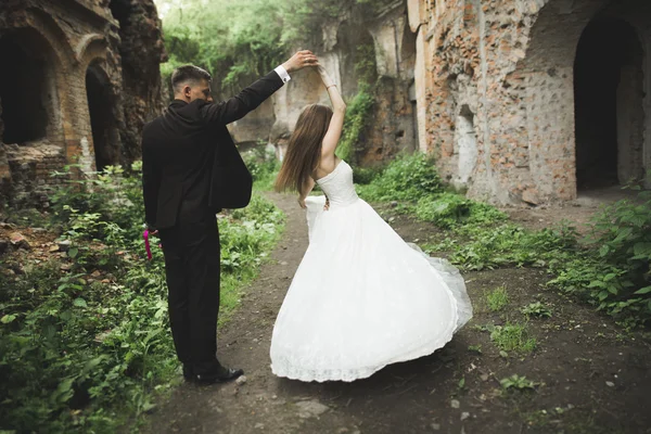 Šťastní novomanželé nedaleko starobylého hradu na procházku — Stock fotografie