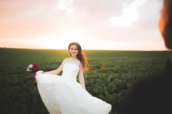 Sposa posa e sorride mentre lo sposo attende sullo sfondo — Foto Stock