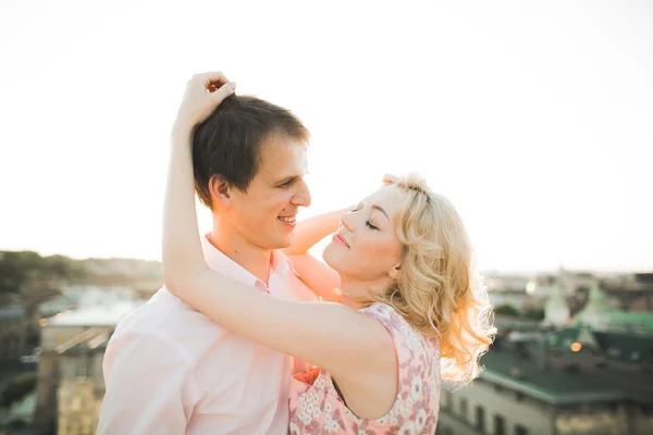 Gros plan portrait de couple souriant heureux en amour posant sur le toit avec de grosses boules. Paysage ville — Photo