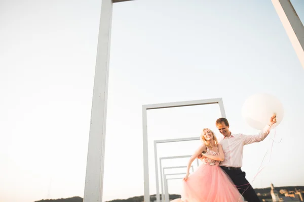 Mode schöne schöne Paar posiert auf dem Dach mit Stadt Hintergrund. junger Mann und sinnliche Blondine im Freien. Lebensstil. — Stockfoto