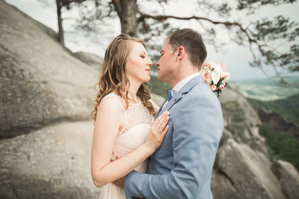 Couple de mariage amoureux embrasser et étreindre près des rochers sur un beau paysage — Photo