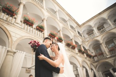 Güzel, mutlu bir düğün çifti, güzel şehirde uzun beyaz elbiseli bir gelin.