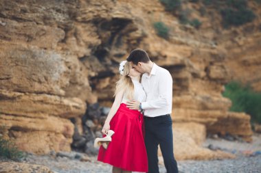 Romantik sevgi dolu çift kayalar ve taşlar Sahilde yürüyüş